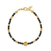 Gold and black beaded bracelet on a white background