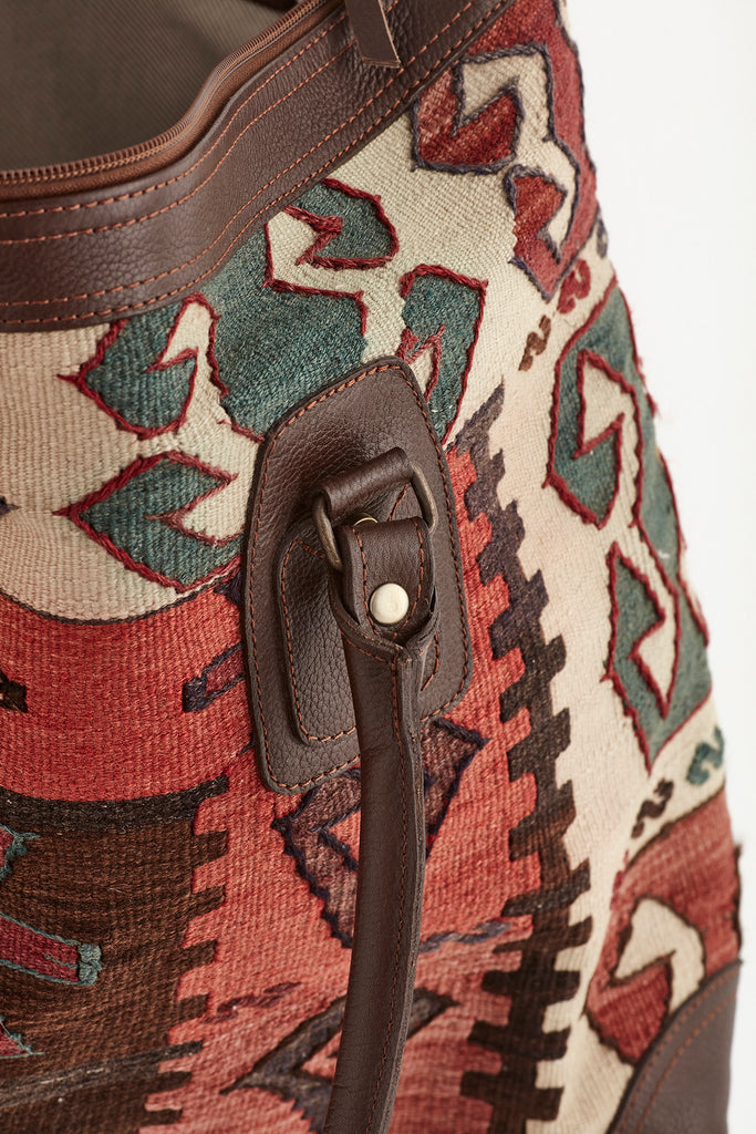 Multi coloured large kilim and leather weekend bag handle detail